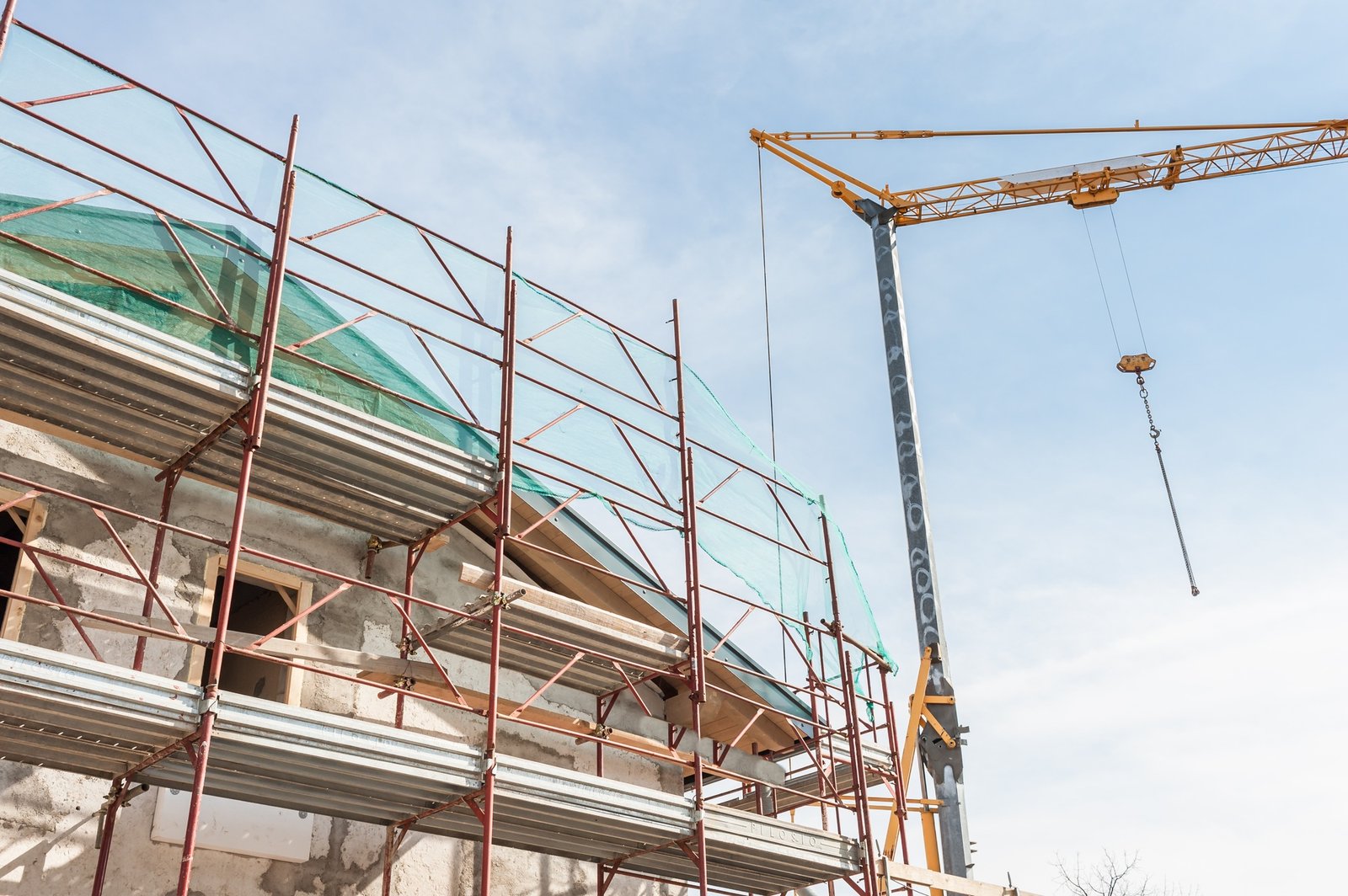 Building armor for house under restoration and crane.
